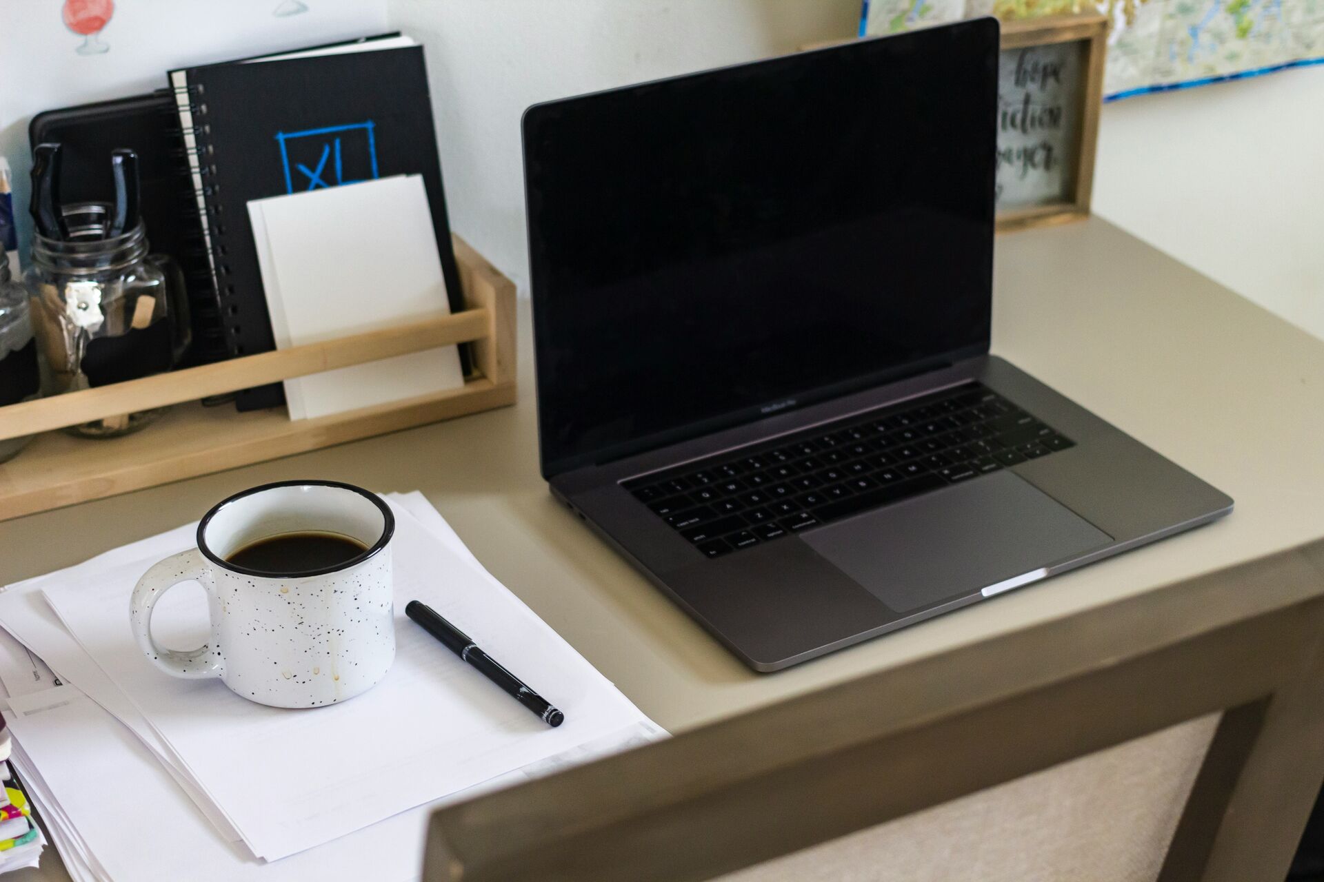 Mesa de trabalho organizada com documentos e notebook, representando o processo de preparação para viagem internacional com pet